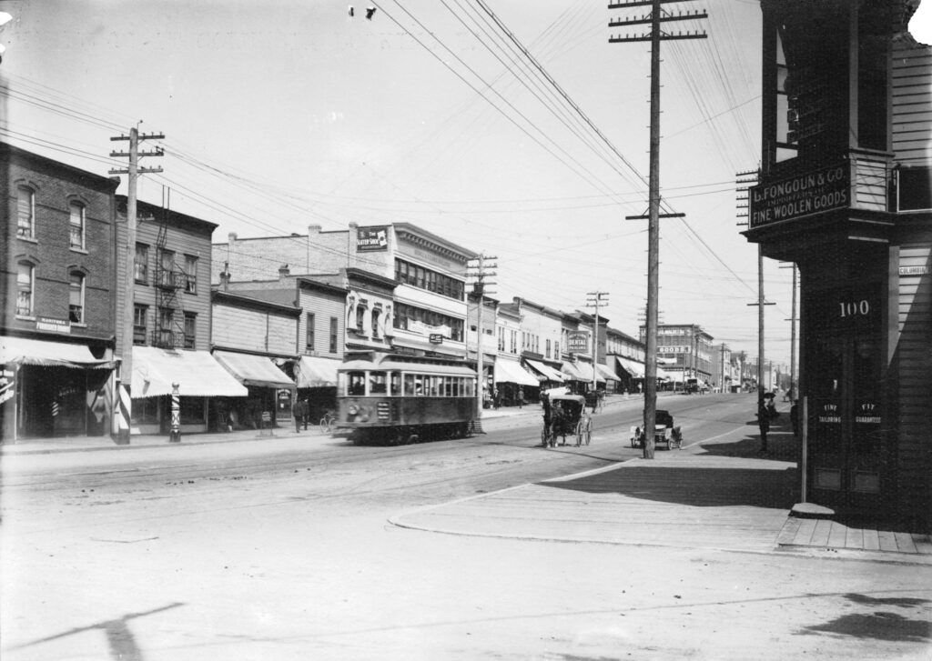 This is Hastings Street East of Columbia Avenue. Many of the old wooden buildings have vanished. The barber poles and the bicycle racks and the old wooden sidewalks, with an occasional nail, kept us from going to sleep as we did our shopping. Timms Photo