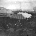 men cooking around circus tent